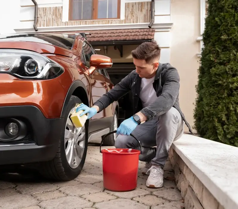 Lavage auto à domicile Guyans-Vennes : professionnel intervenant sur un véhicule